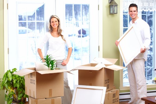 Movers carrying furniture through a narrow Camdentown staircase
